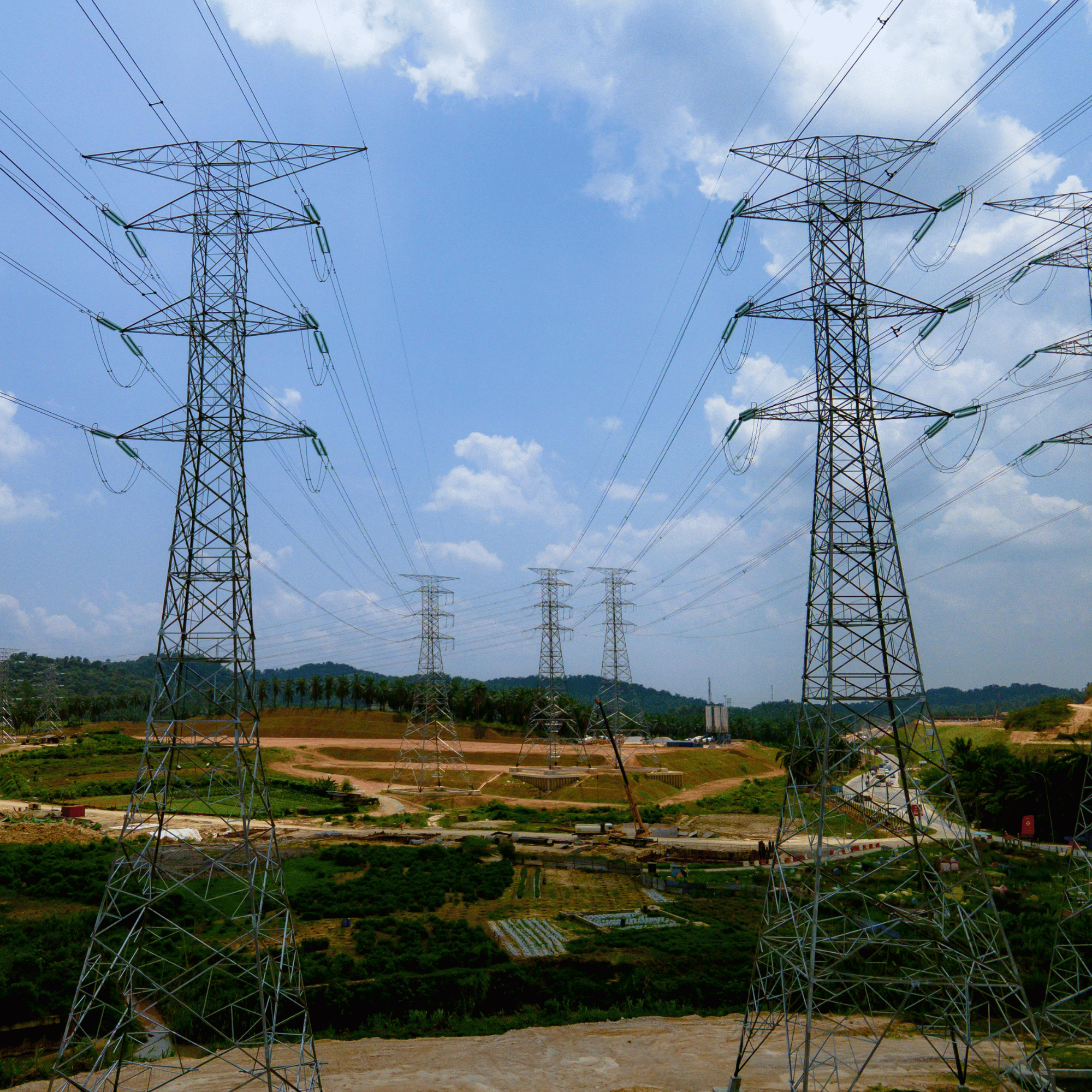 High-voltage transmission towers crossing a rural landscape